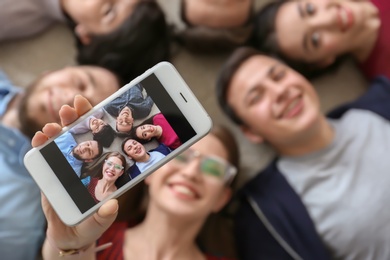 Happy friends taking selfie indoors