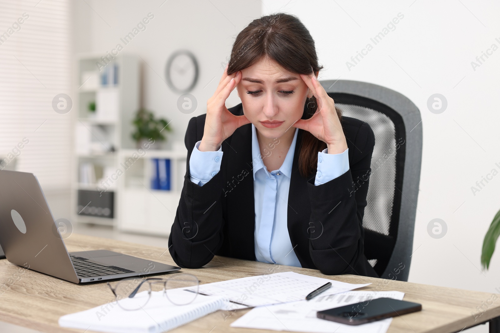 Photo of Overwhelmed woman suffering at table in office