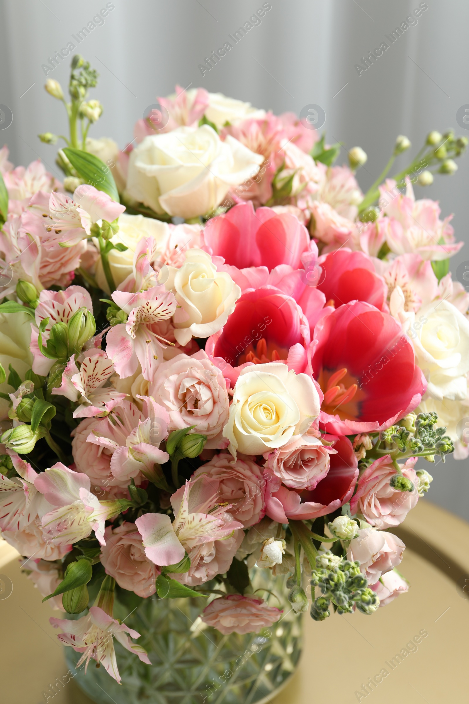 Photo of Beautiful bouquet of fresh flowers on coffee table in room