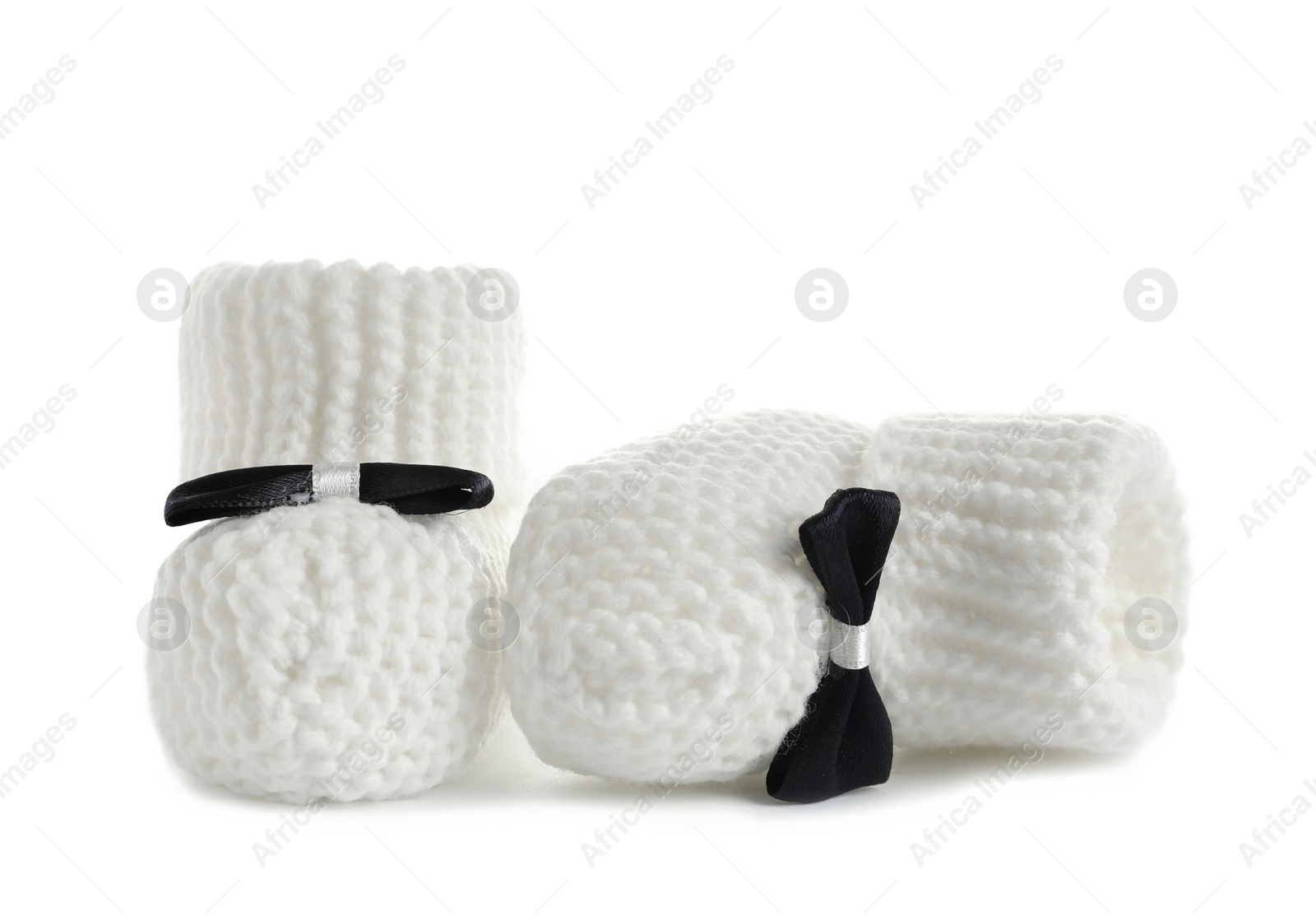 Photo of Handmade baby booties with bows isolated on white