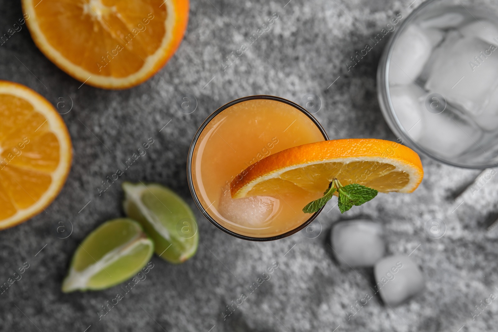 Photo of Fresh alcoholic Tequila Sunrise cocktail on grey table, flat lay