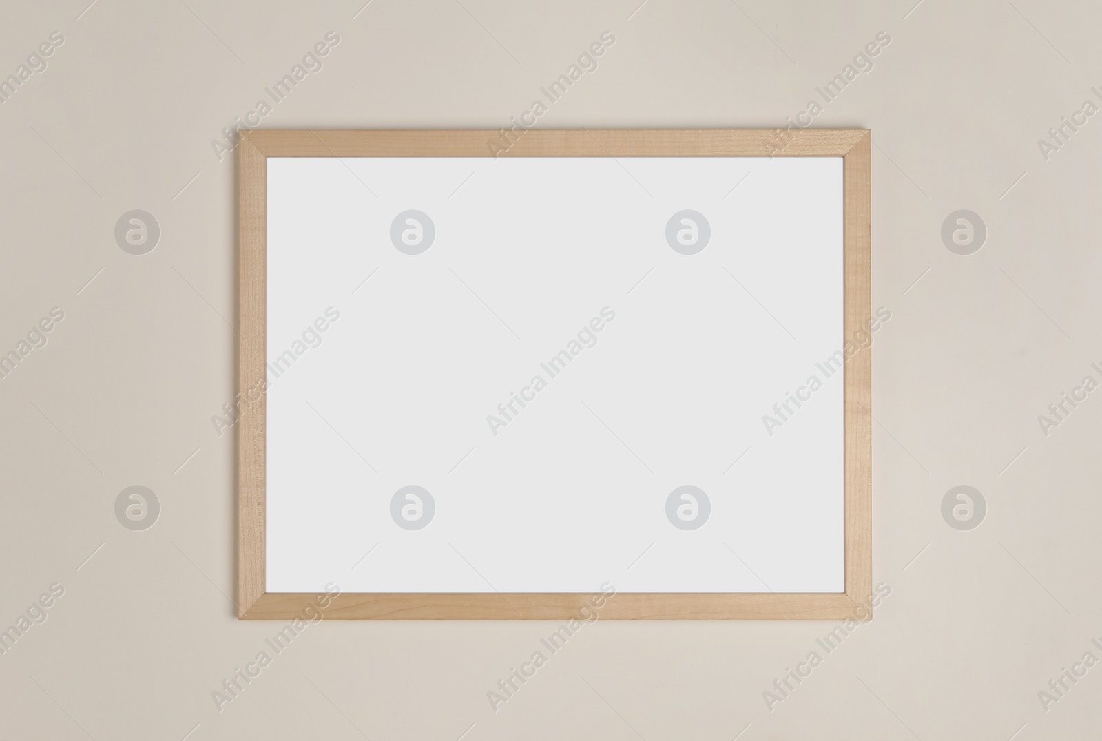 Photo of Blank frame hanging on light wall. Space for design