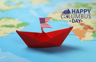 Image of Happy Columbus Day. Red paper boat with American flag on world map
