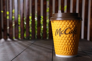 MYKOLAIV, UKRAINE - AUGUST 12, 2021: Hot McDonald's drink on wooden table. Space for text