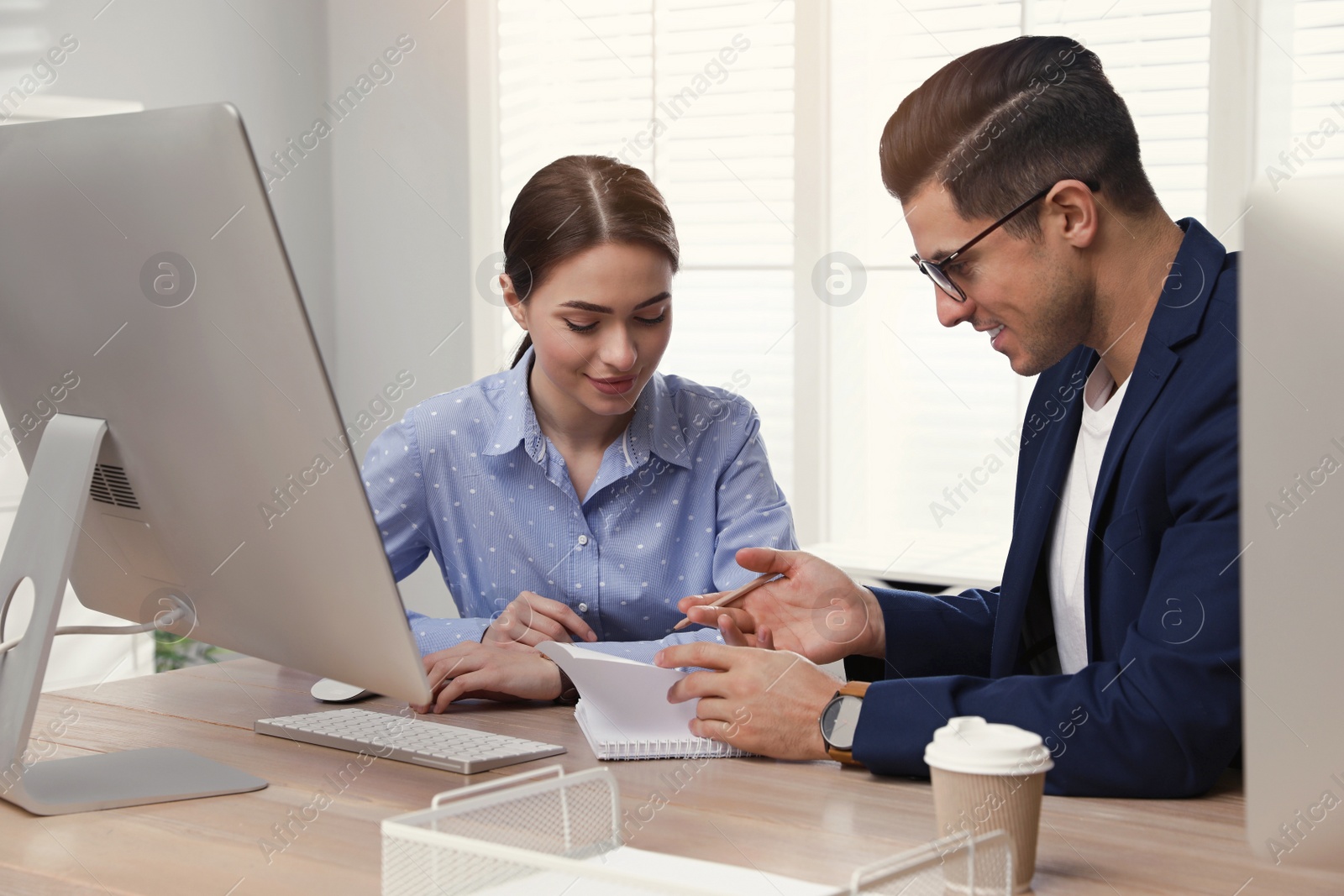 Photo of Businessman helping intern with work in office