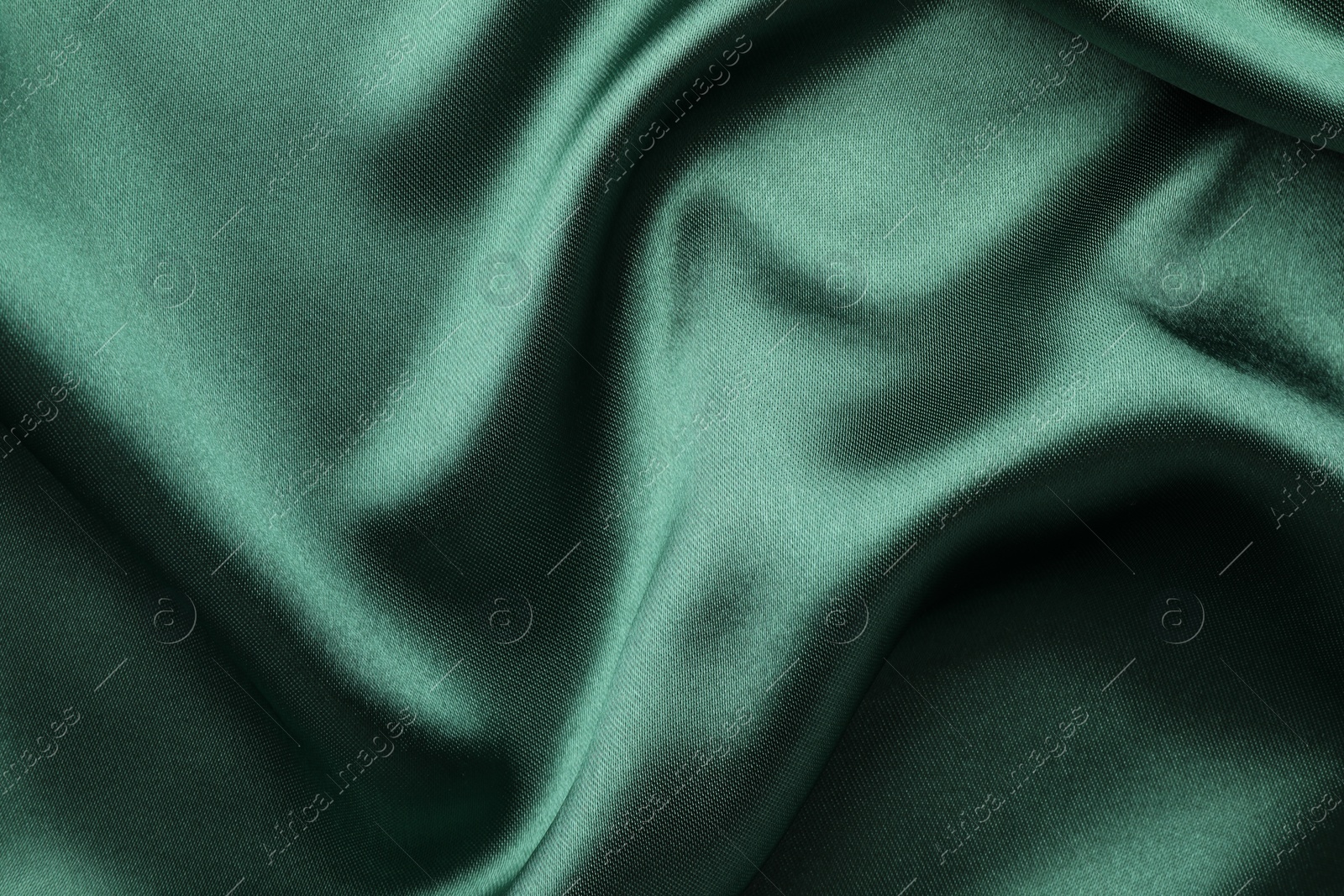 Photo of Crumpled green silk fabric as background, top view