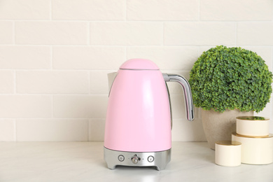 Photo of Modern electric kettle on counter in kitchen