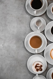 Cups of fresh aromatic coffee on grey background, top view