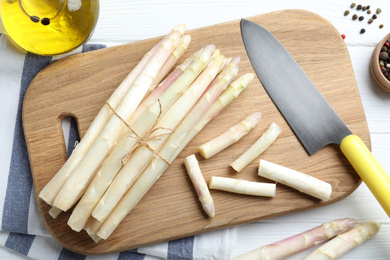 Fresh white asparagus on wooden table, flat lay