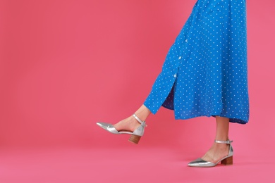 Woman in stylish shoes on pink background. Space for text