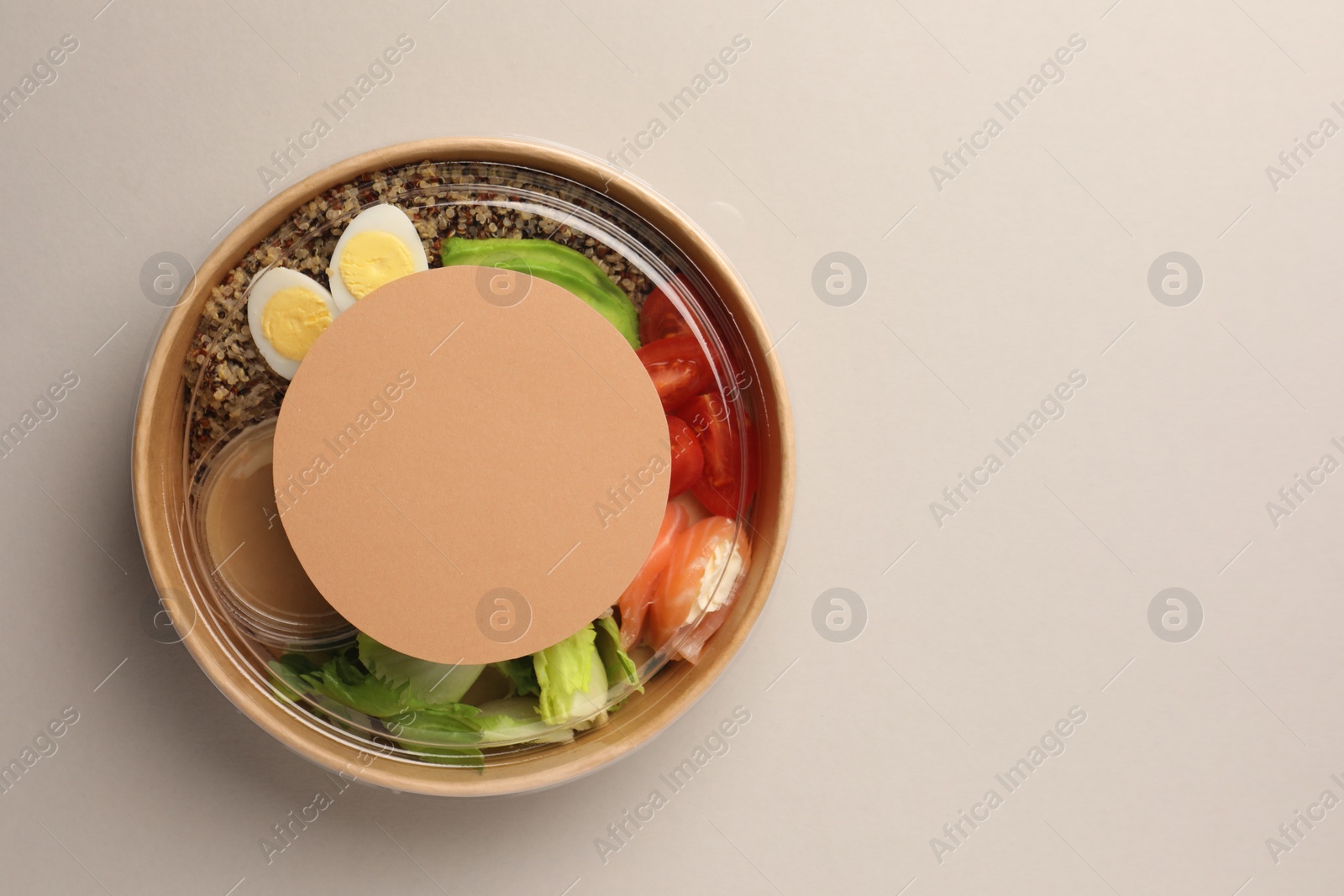 Photo of Tasty food in container on light background, top view. Space for text