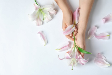 Photo of Woman with beautiful lily flower on white background, top view