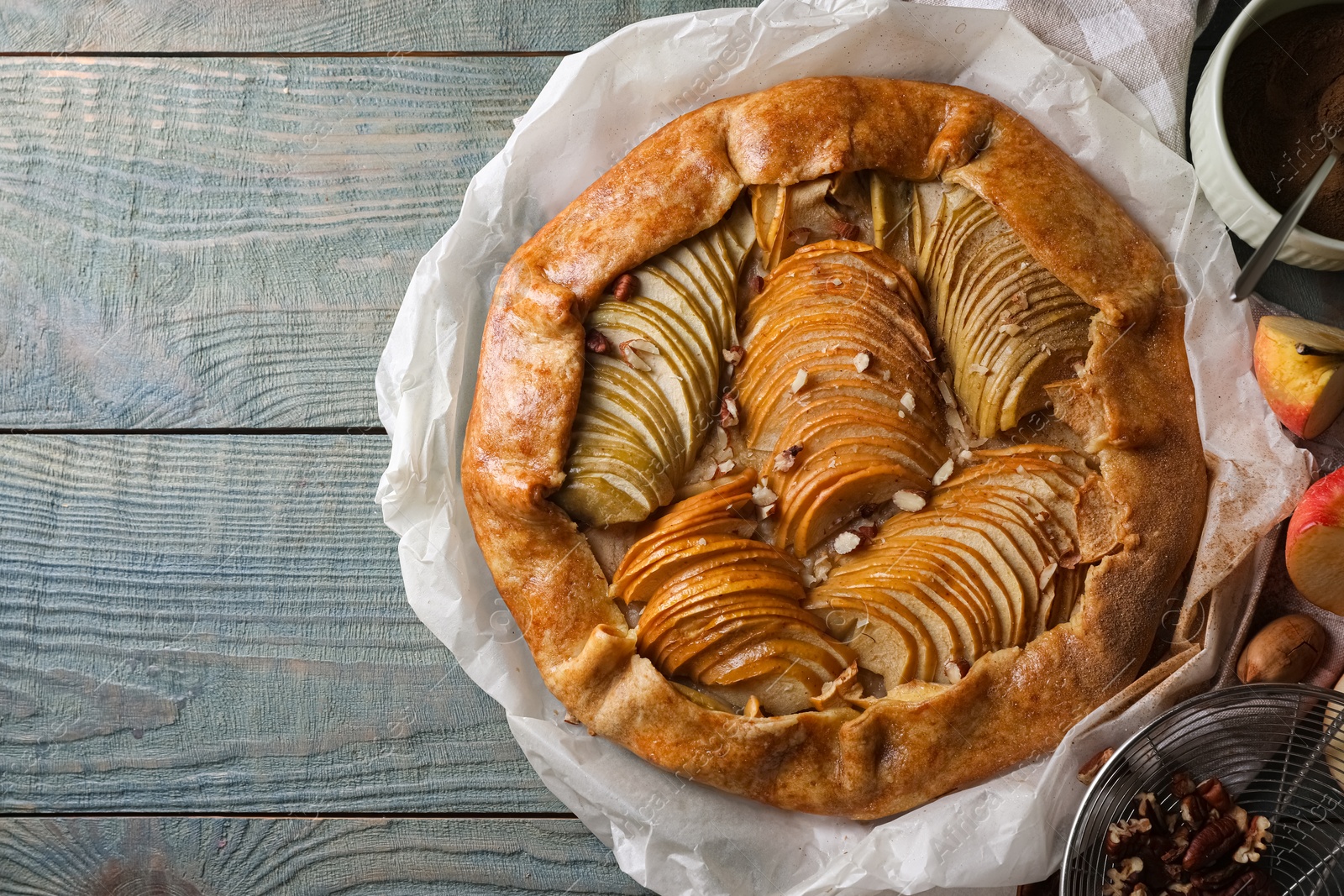 Photo of Delicious apple galette with pecans on wooden table, flat lay. Space for text