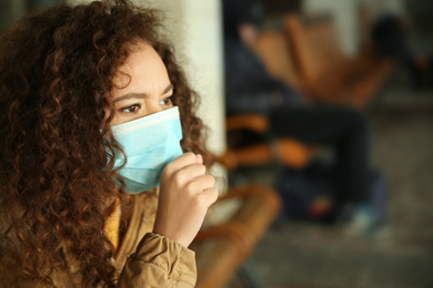 African-American woman with disposable mask indoors. Virus protection