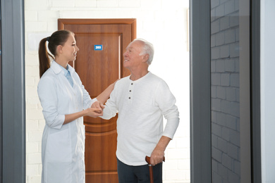 Doctor with senior patient at modern hospital