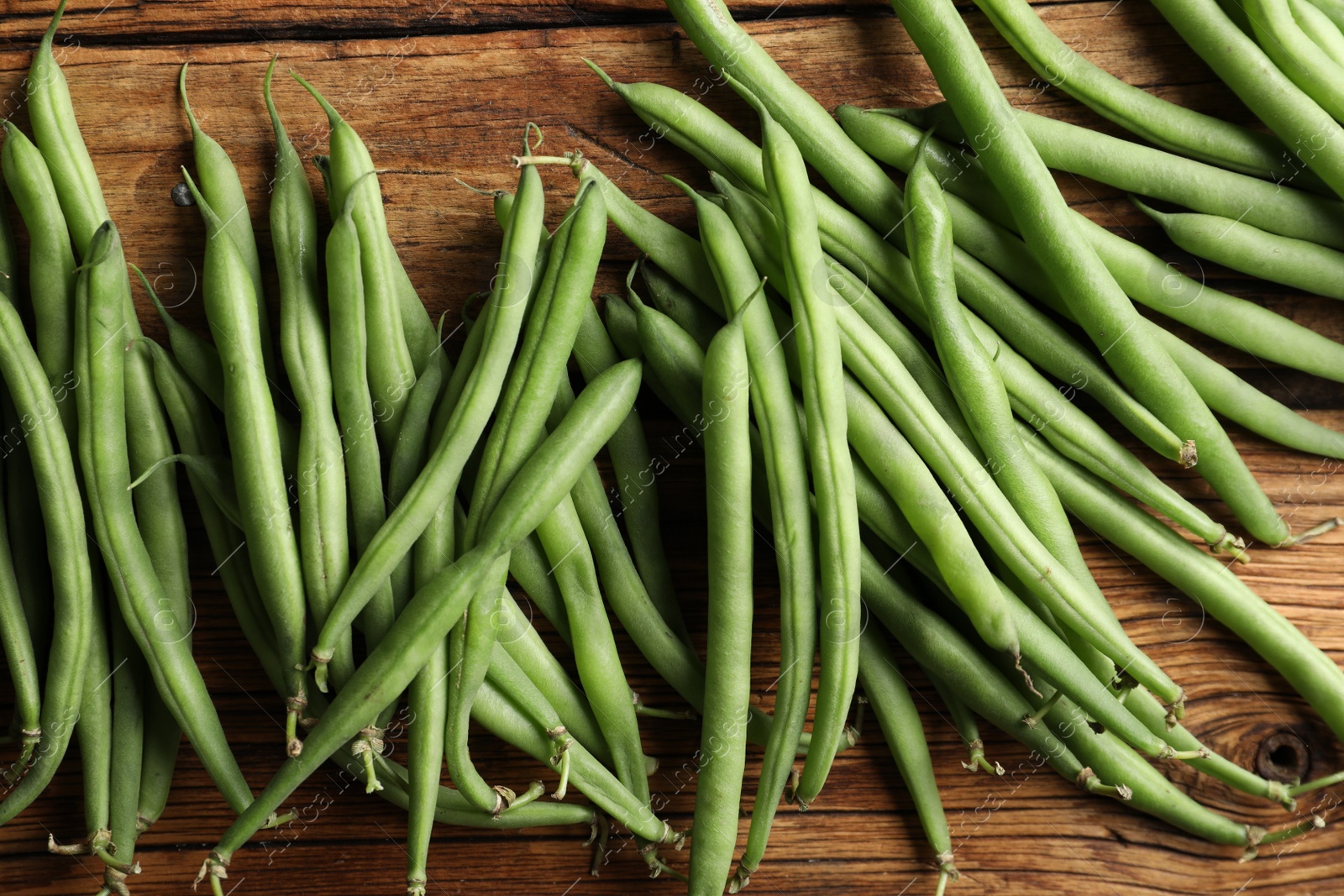 Photo of Fresh green beans on wooden table, flat lay