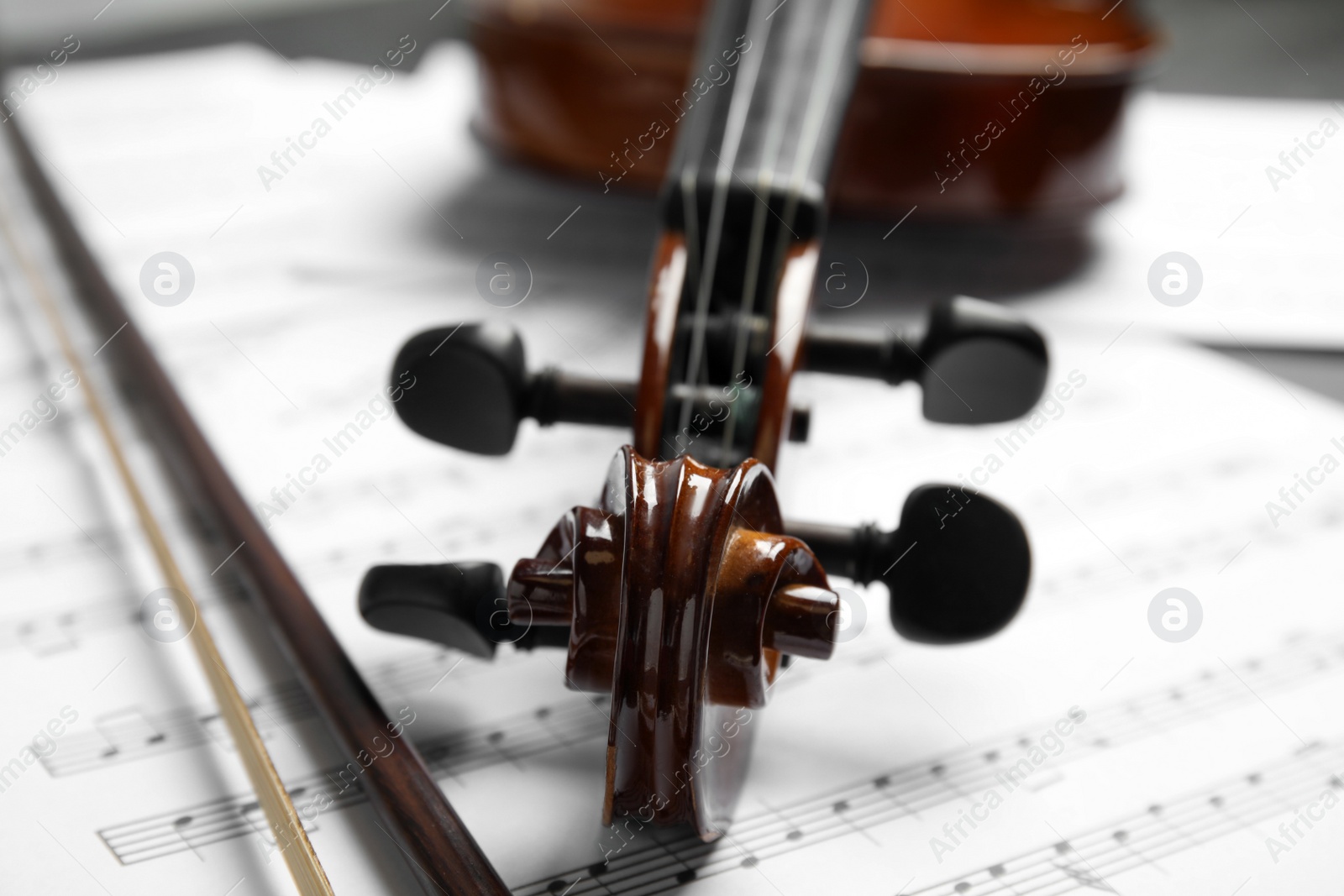 Photo of Classic violin, bow on note sheets, closeup