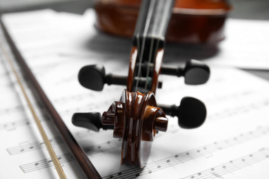 Photo of Classic violin, bow on note sheets, closeup