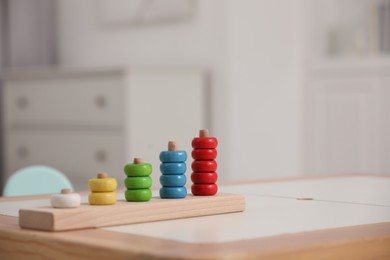 Photo of Stacking and counting game wooden pieces on table indoors, space for text. Educational toy for motor skills development