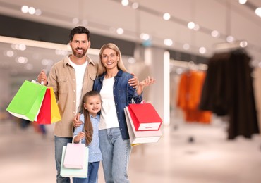 Happy family with shopping bags walking in mall