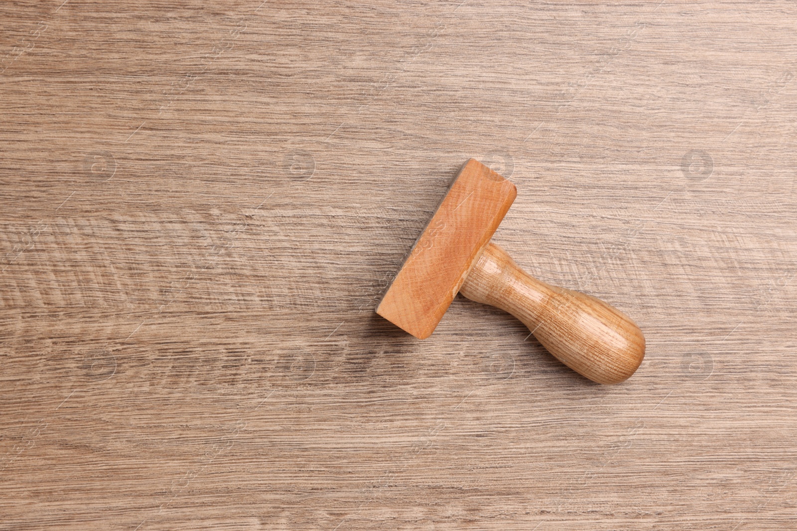 Photo of One stamp tool on wooden table, top view. Space for text