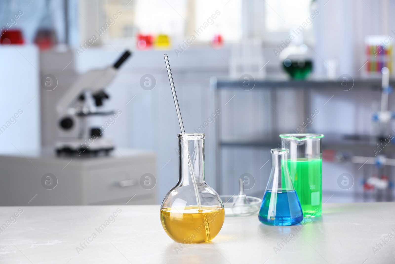 Photo of Laboratory glassware with samples on table indoors, space for text. Solution chemistry