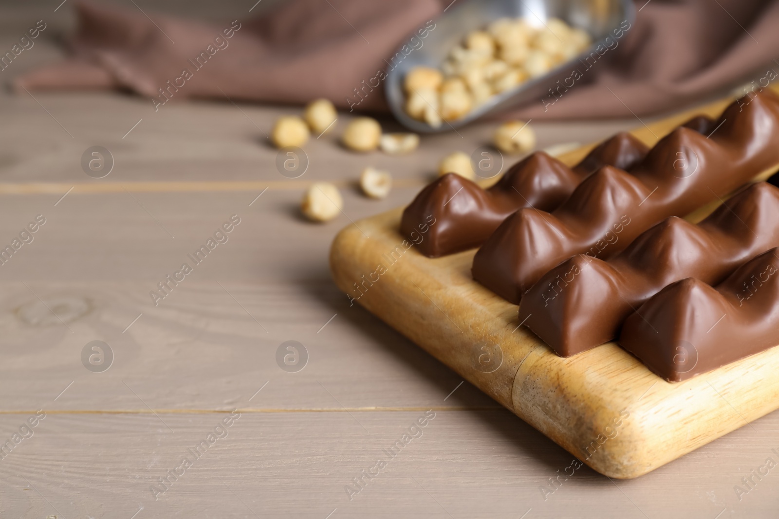 Photo of Tasty chocolate bars on wooden table, space for text