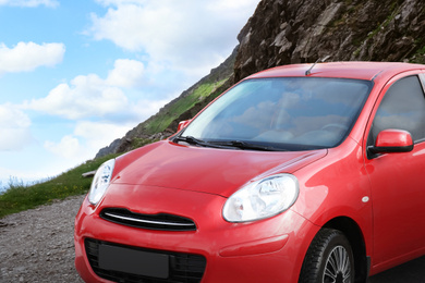 Image of Road trip. Car parked near mountains on cloudy day 