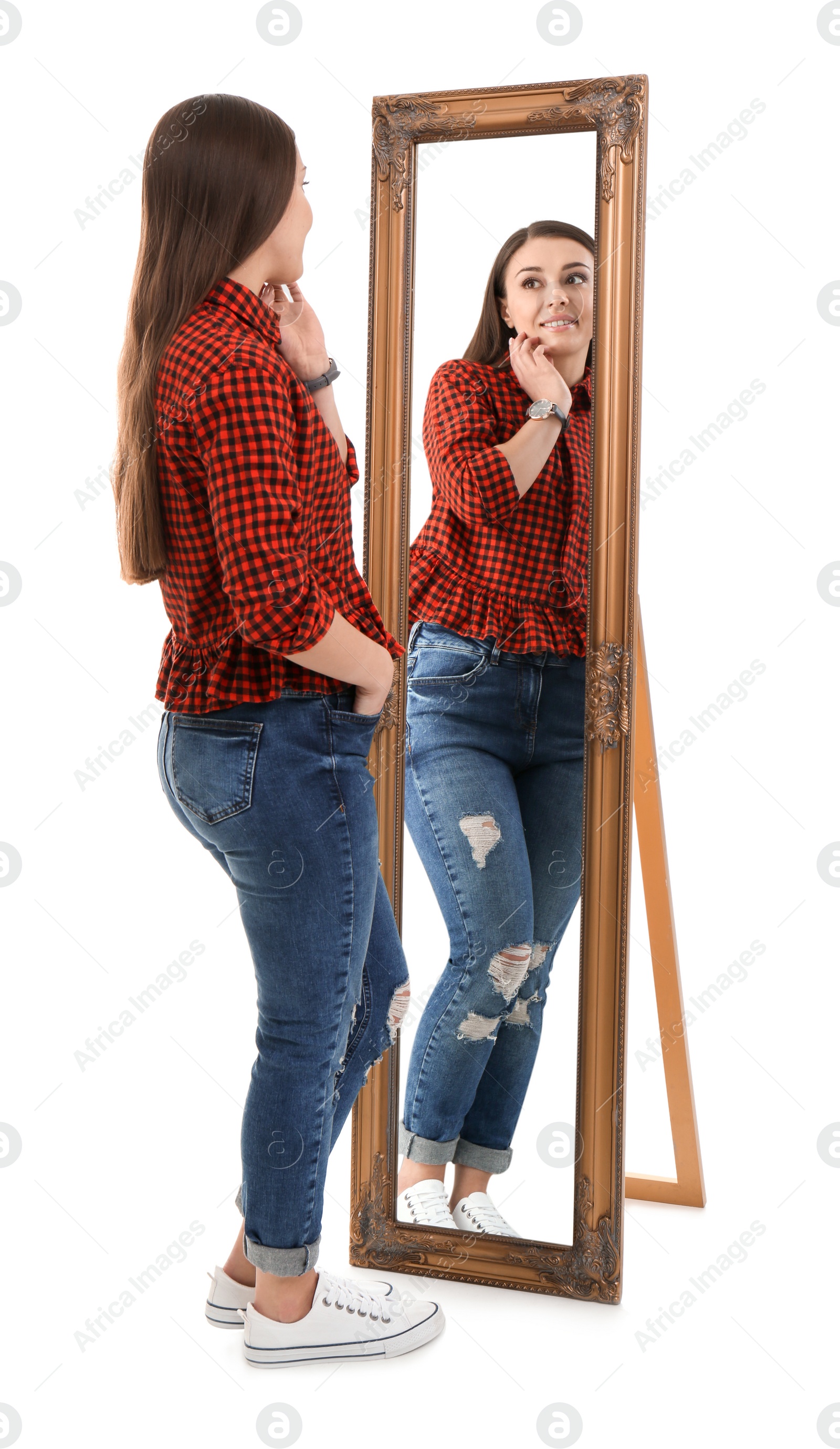 Photo of Young woman looking at her reflection in mirror on white background