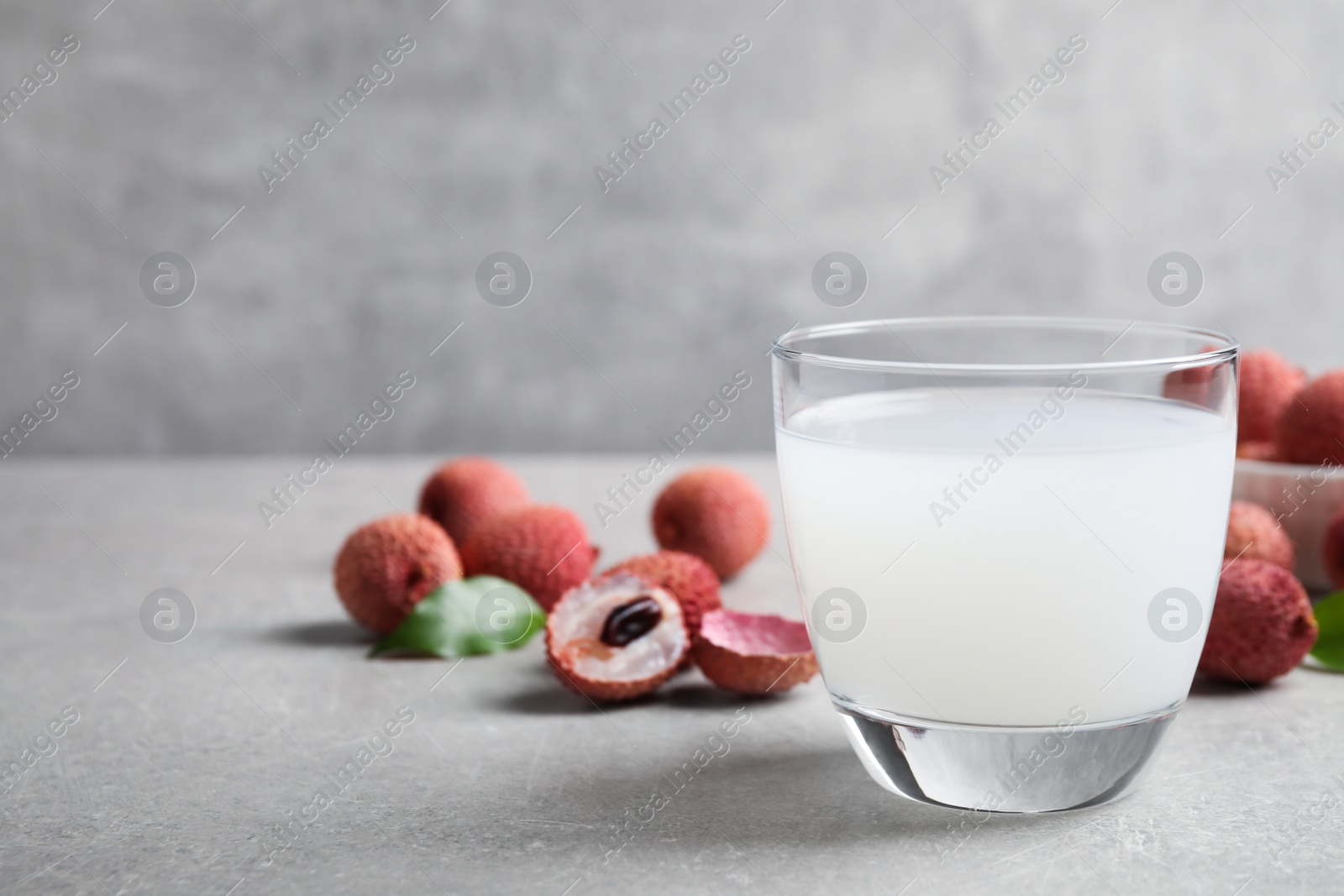 Photo of Freshly made lychee juice on light table. Space for text