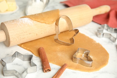 Making homemade Christmas cookies. Rolling pin, dough and cutters on table, closeup