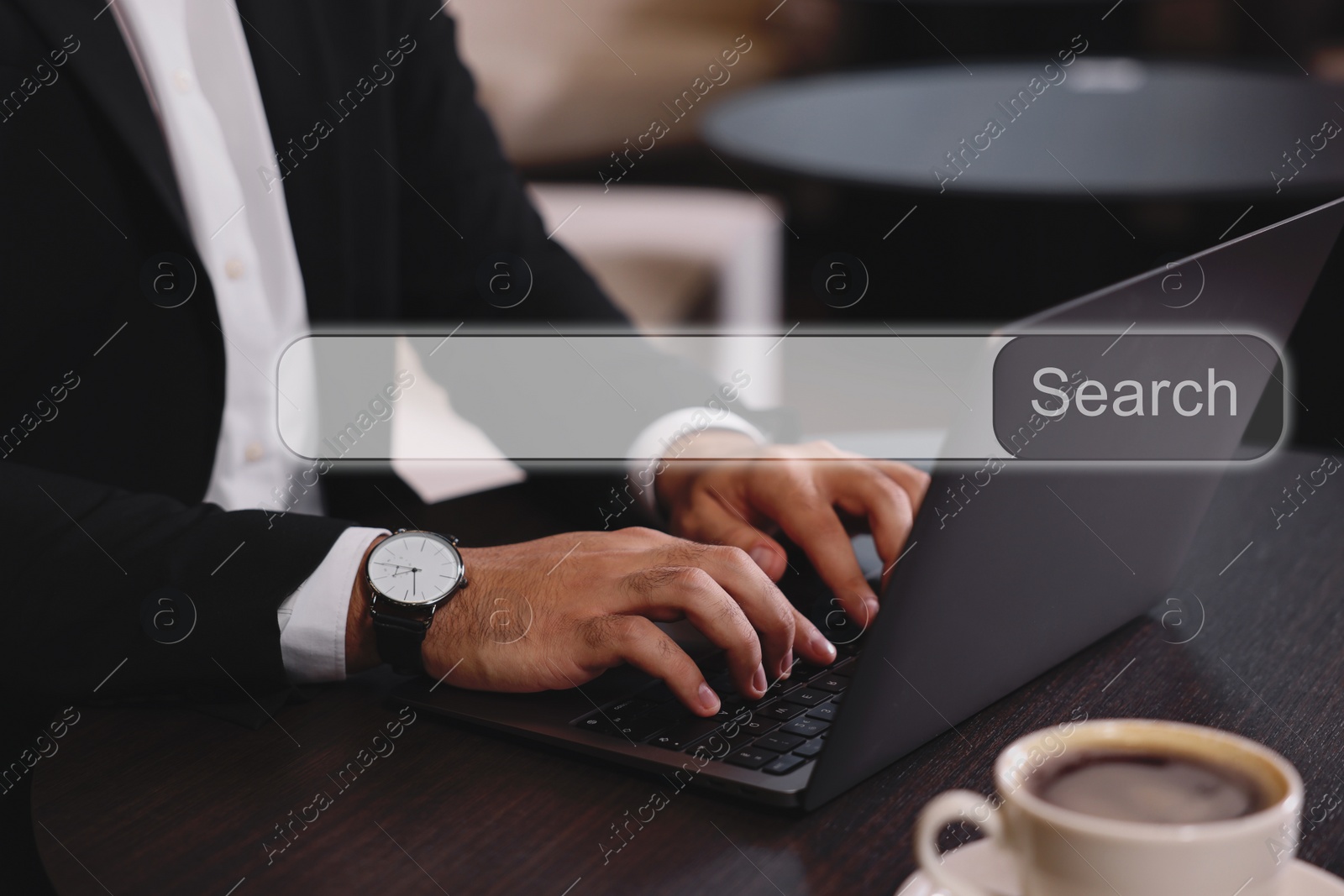 Image of Search bar of website over laptop. Man using computer at wooden table, closeup