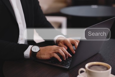 Search bar of website over laptop. Man using computer at wooden table, closeup