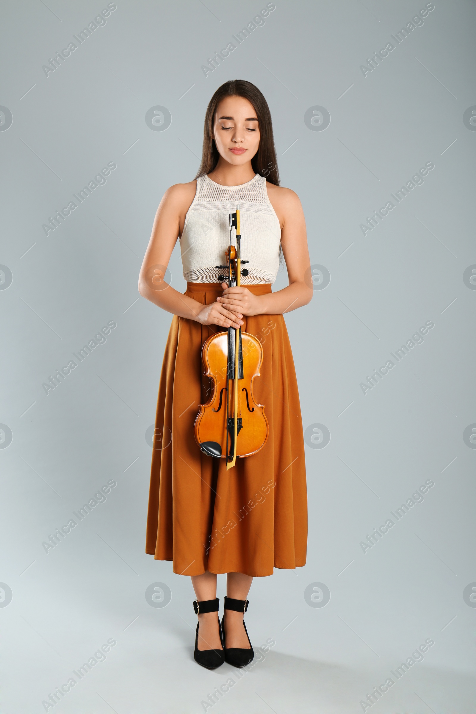 Photo of Beautiful woman with violin on grey background