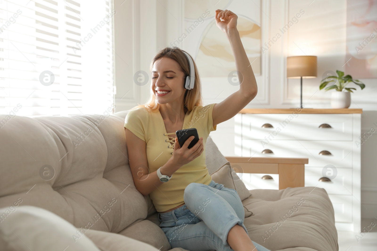 Photo of Young woman listening to music at home