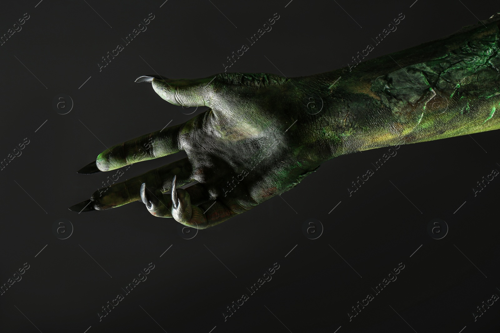 Photo of Scary monster on black background, closeup of hand. Halloween character