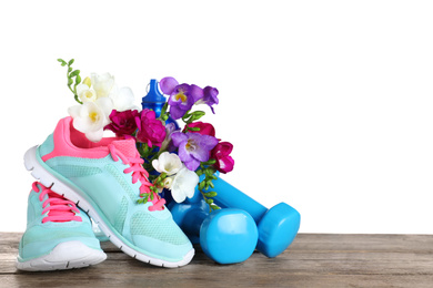 Photo of Composition with spring flowers and sports items on wooden table against white background, space for text