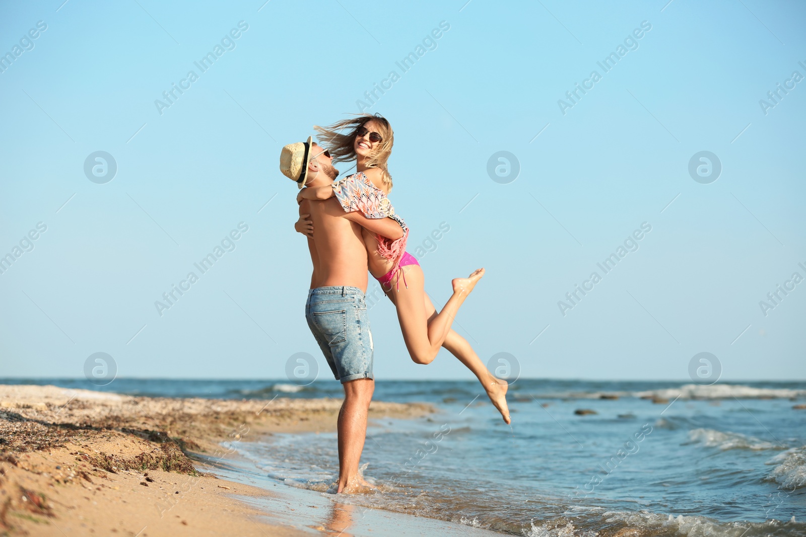 Photo of Young couple spending time together on beach