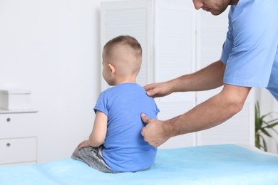 Photo of Orthopedist examining child's back in clinic, closeup. Scoliosis treatment