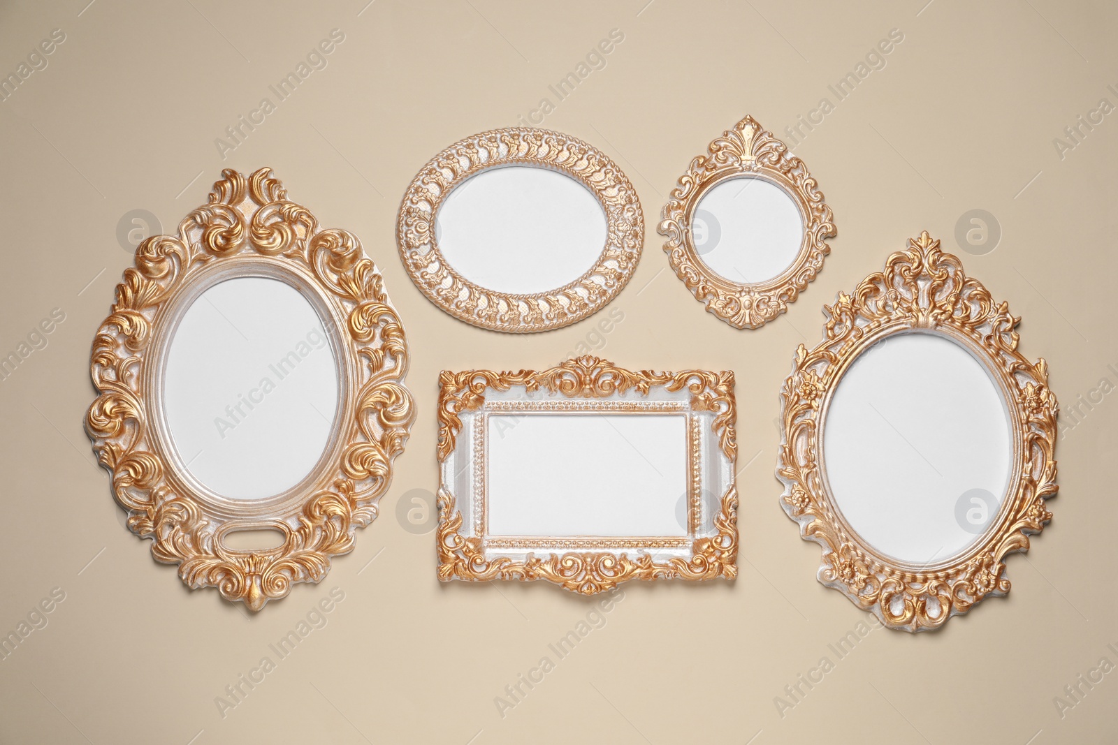 Photo of Empty vintage frames hanging on beige wall