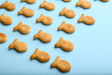 Photo of Delicious goldfish crackers on light blue background, closeup