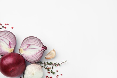 Fresh red onions, garlic, thyme and spices on white background, flat lay. Space for text