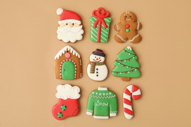 Photo of Different Christmas gingerbread cookies on brown background, flat lay