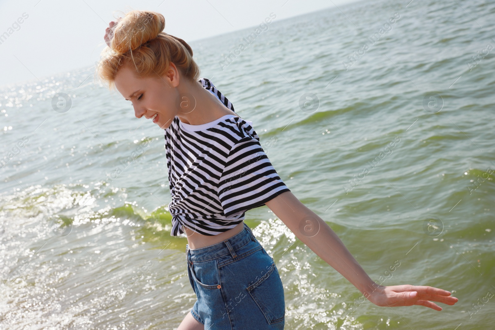 Photo of Beautiful young woman near sea on sunny day in summer