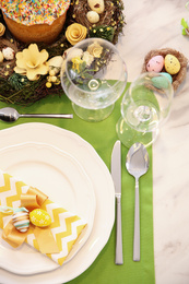 Photo of Festive table setting with traditional Easter bread, flat lay