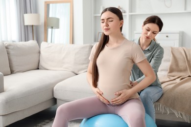 Doula working with pregnant woman at home. Preparation for child birth