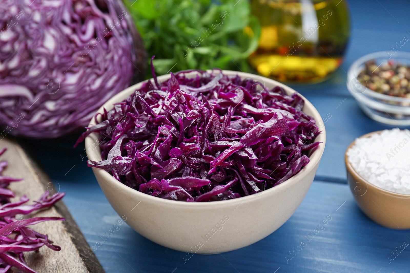 Photo of Tasty red cabbage sauerkraut and different ingredients on light blue wooden table