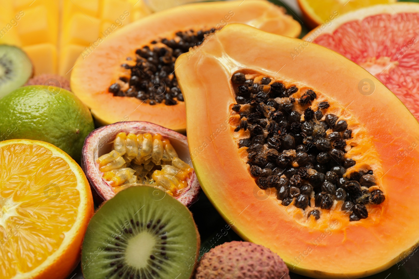 Photo of Fresh ripe papaya and other fruits as background, closeup