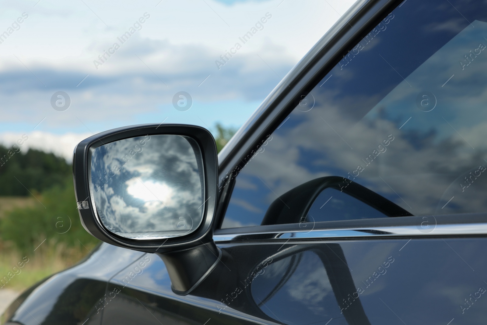 Photo of New black modern car outdoors, closeup of side rear view mirror