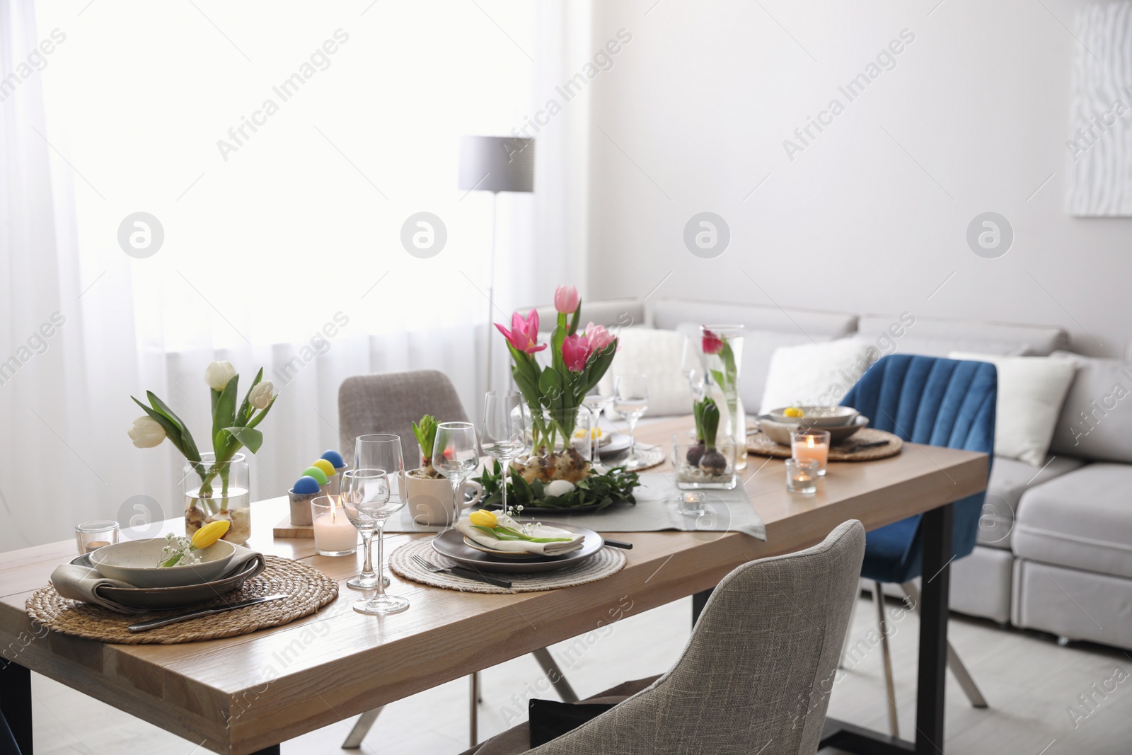 Photo of Beautiful Easter table setting with beautiful flowers in living room